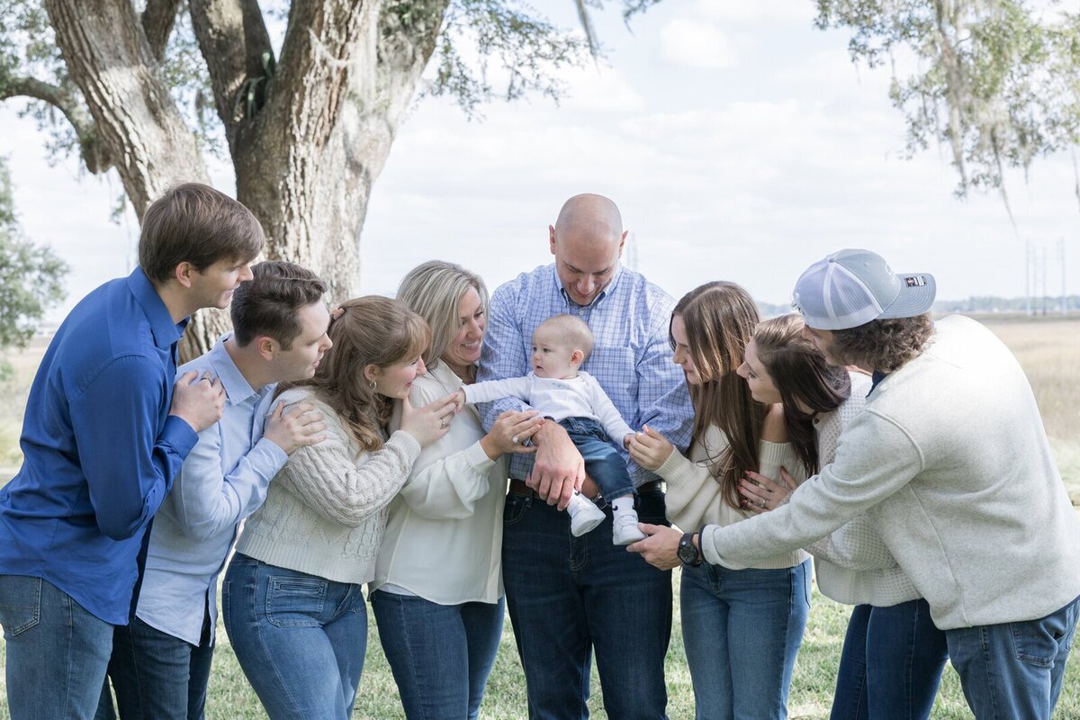 family all looking at newborn baby by Savannah family photographer Tiffany Bradley