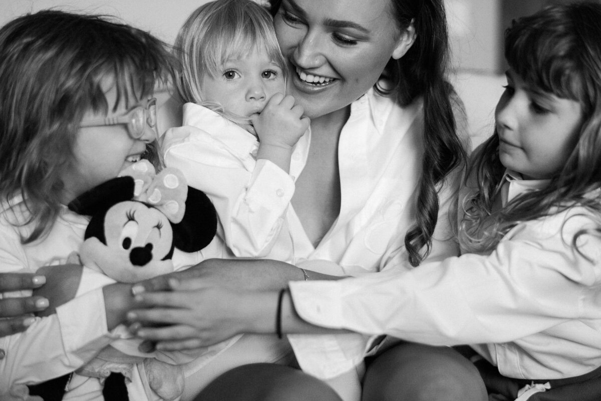 A woman holds children closely