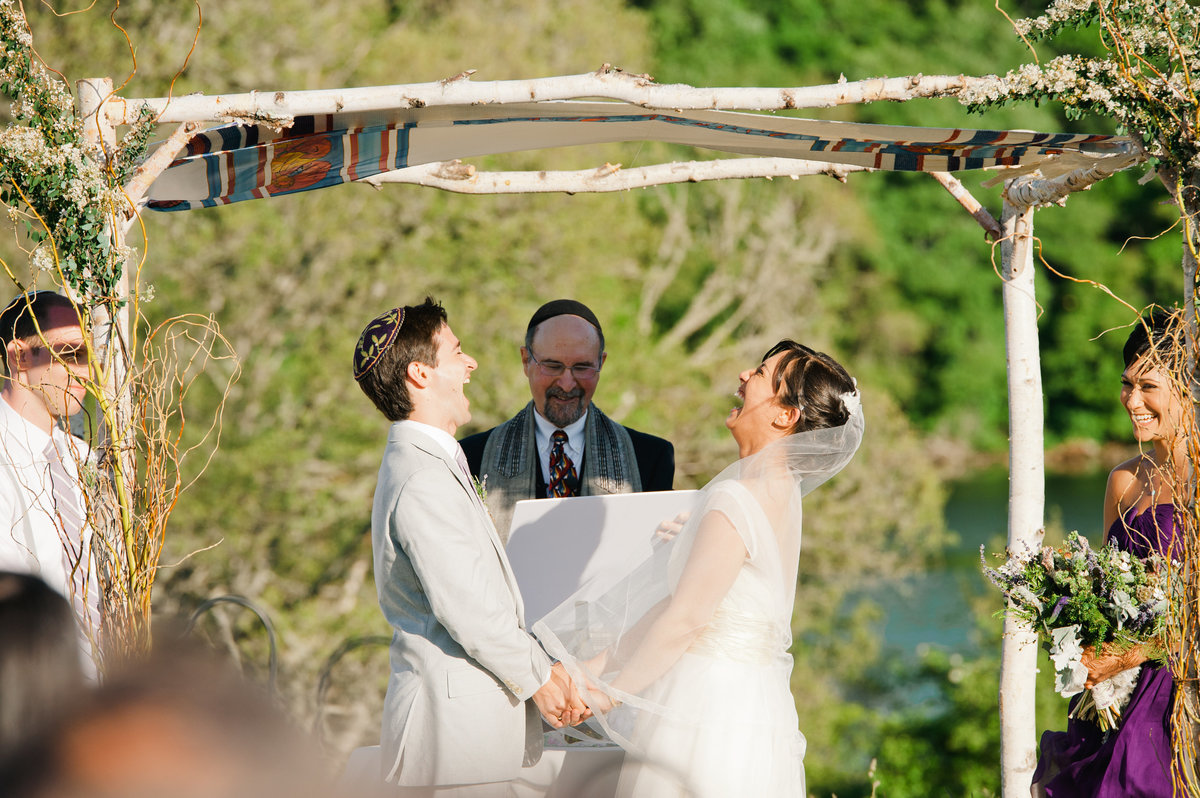 Bride and groom laugh during ceremony