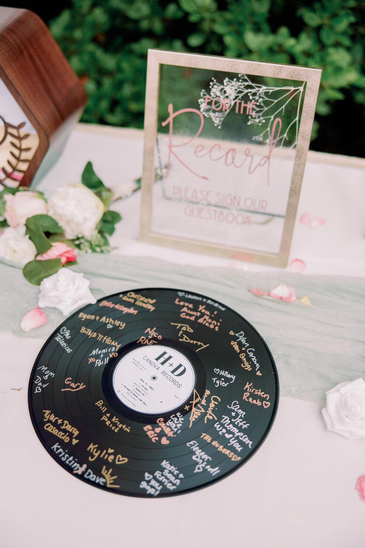 A vinyl signed by wedding guests sitting on a table 