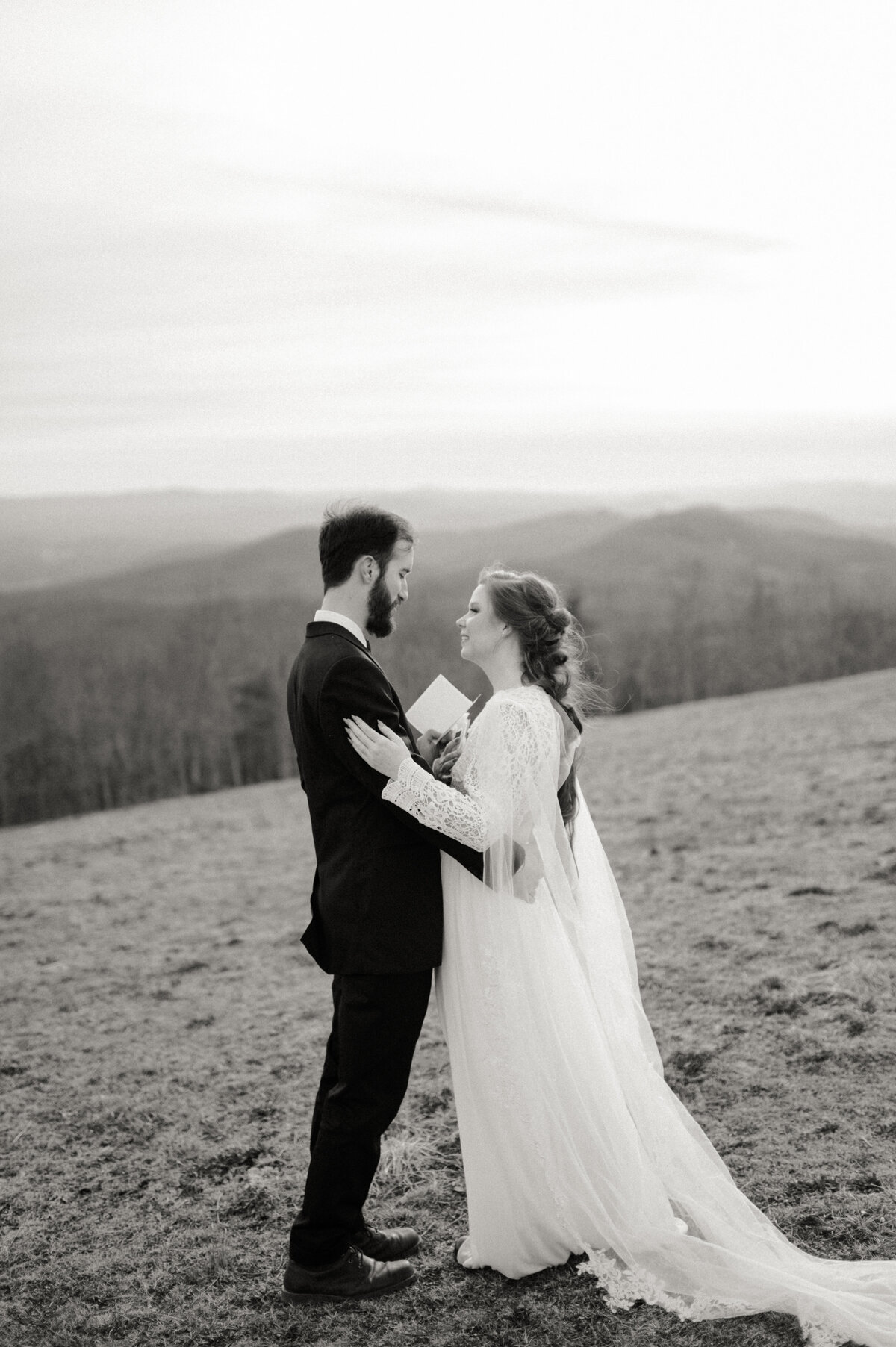 bride and groom read vows with the mountains in the background