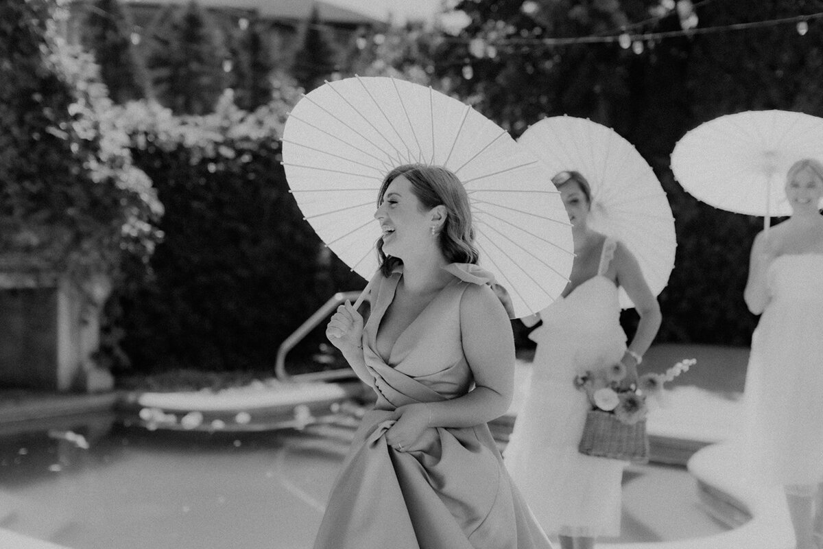 Bride and bridesmaids smiling with umbrellas at the Club Corazon