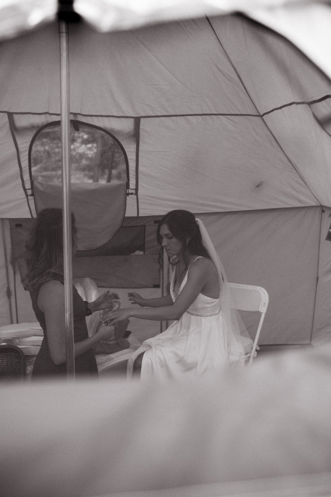 Bride sitting near tent at mountain wedding