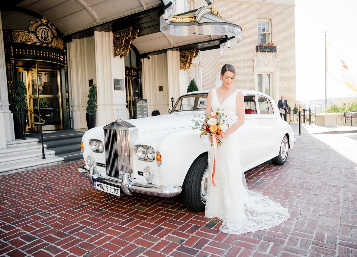 bride with bouquet in front of classic car