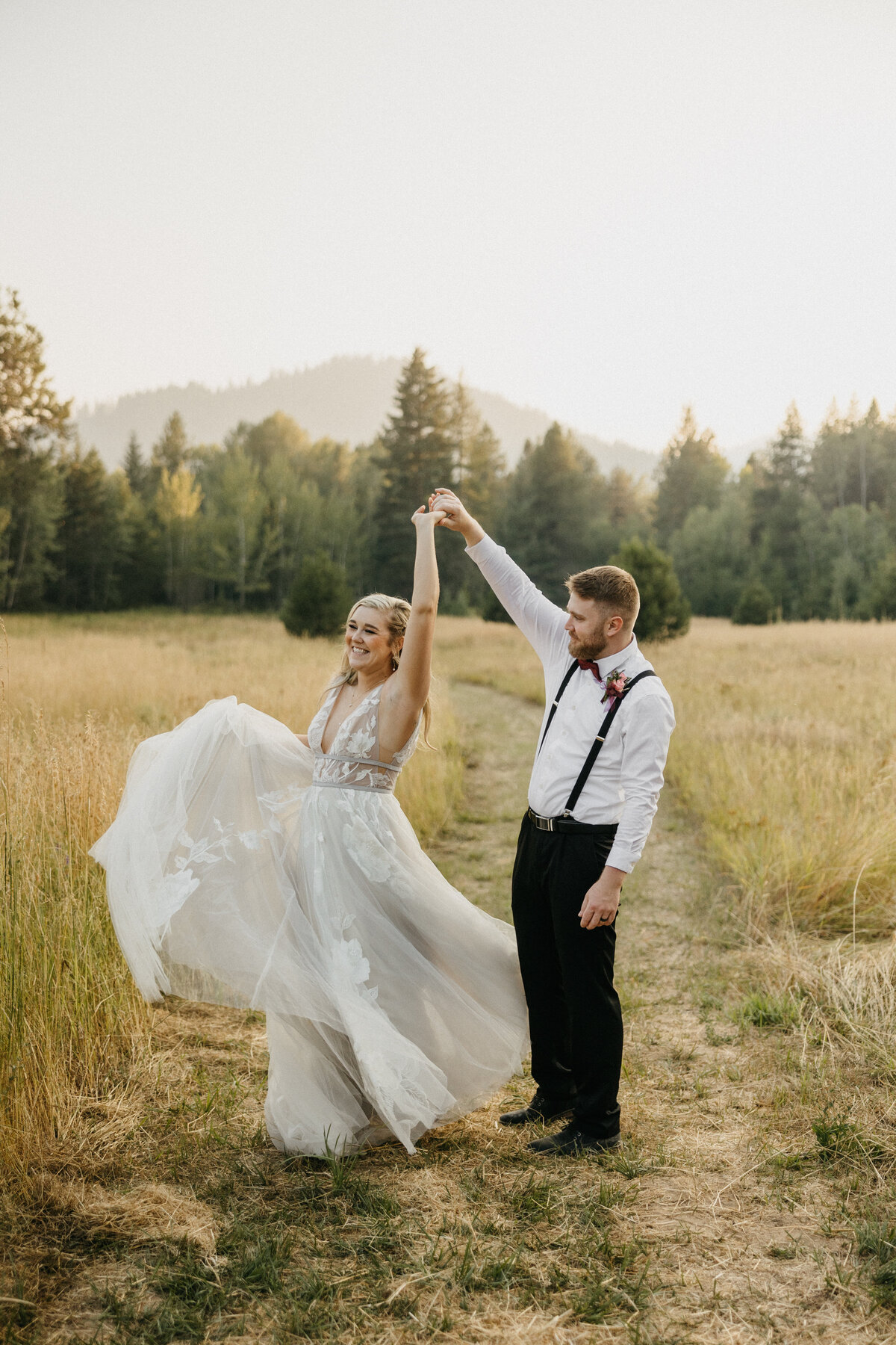 bride and groom dancing in a field