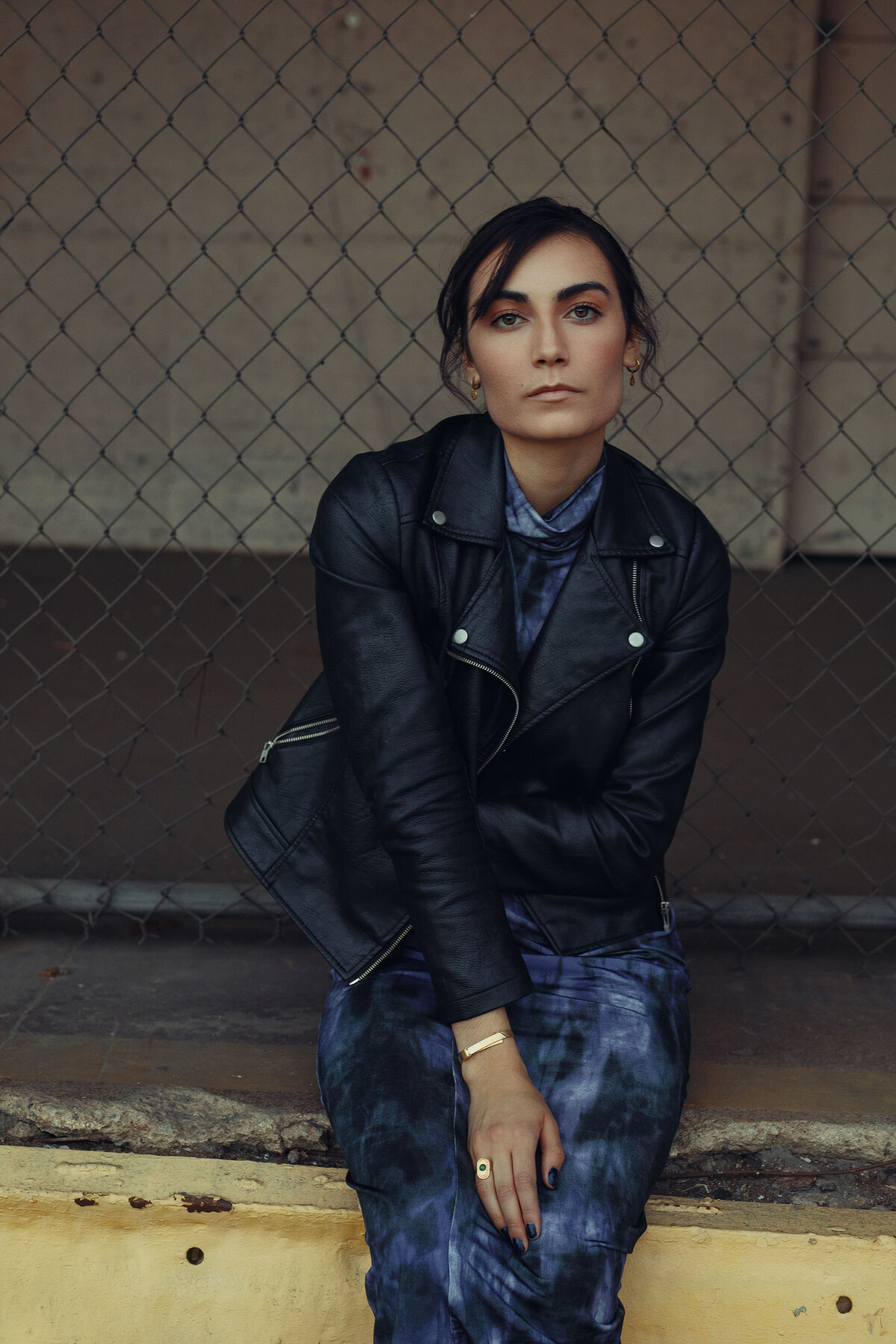Portrait Photo Of Young Woman In Black Leather Jacket Sitting On Cement Ground Los Angeles