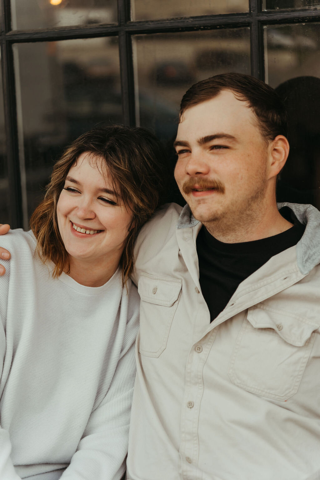 Candid photo of couple cuddling together on bench