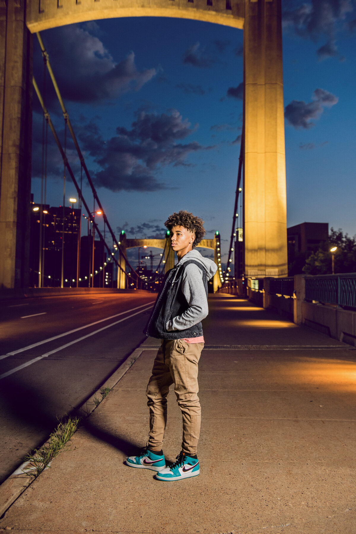 high school senior boy on bridge at night