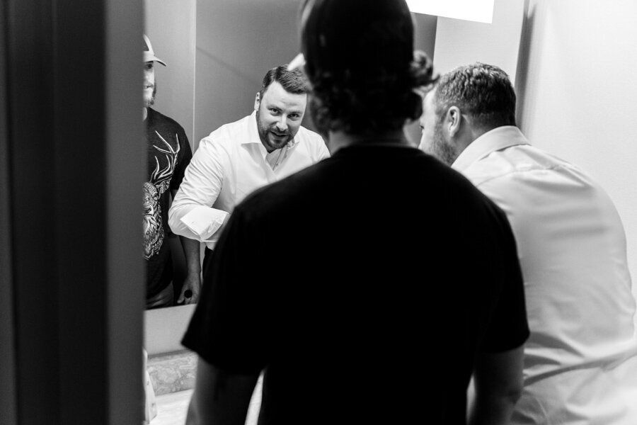 Groom-getting-ready-intercon-suite