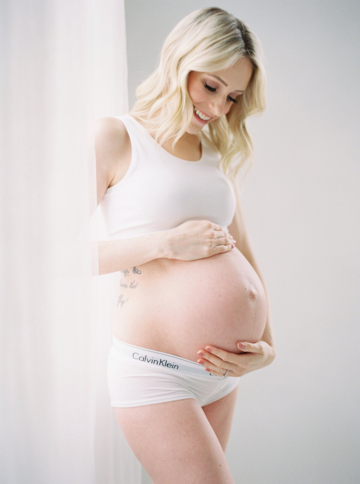 Bare bump maternity photo of mom in white Calvin Klien sports bra and briefs captured by Seattle Maternity Photographer