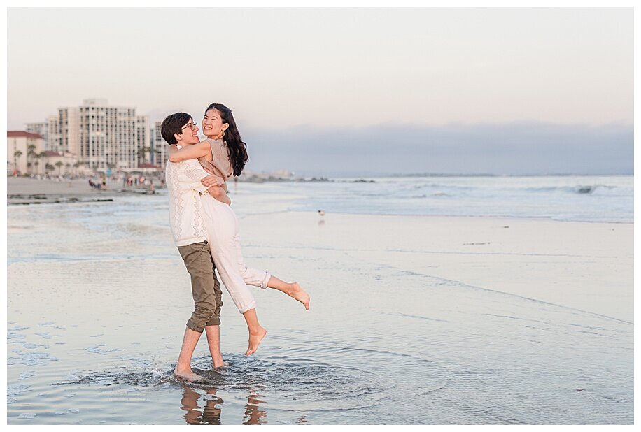engaged couple twirling on Coronado Beach