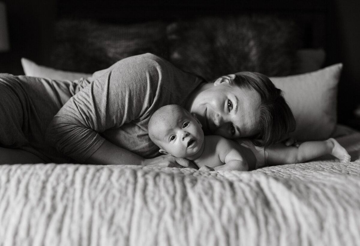 Mom laying in bed with newborn baby girl in Chicago, IL