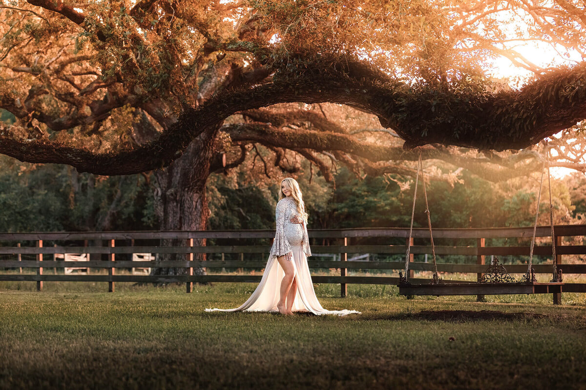 Stunning blonde mom to be under a centennial tree in Houston, TX.
