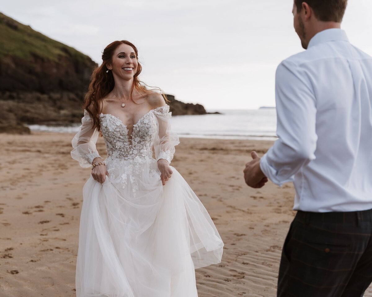 Married couple having fun whilst being photographed on the beach