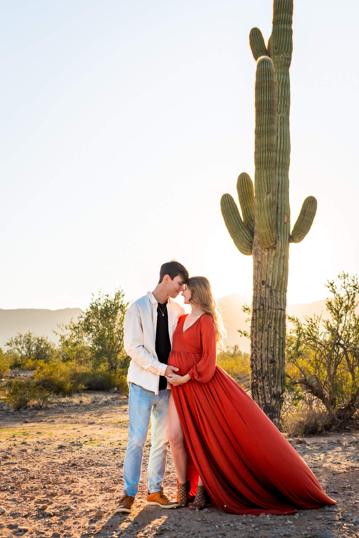 Arizona parents-to-be holding each other close at sunset.