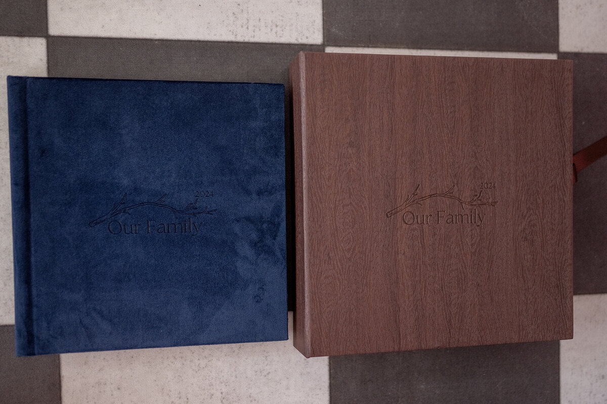 A blue velvet album sits next to a leather box that looks like wood grain