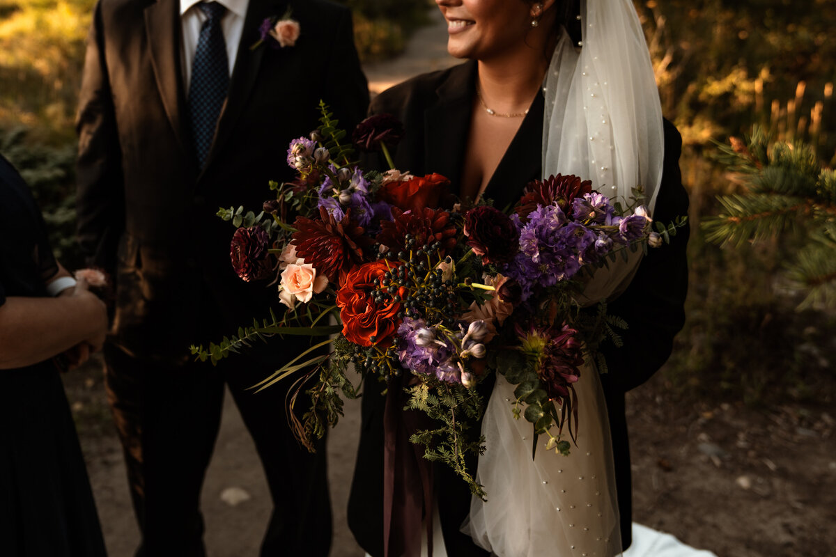 Bride poses with jewel toned bridal bouquet in Bend, Oregon
