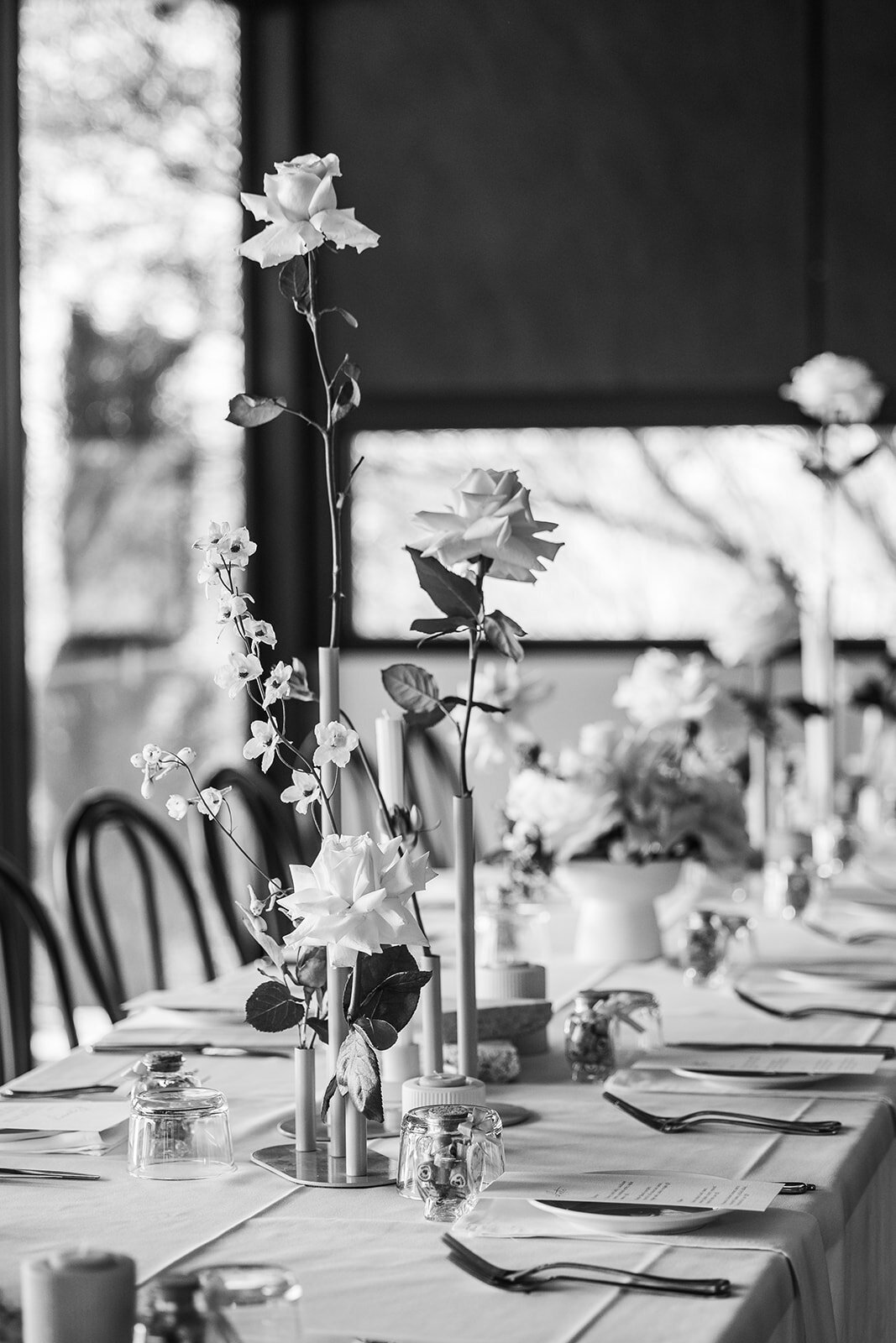 Black and white images of bud vases on wedding reception table at Brindabella Hills Winery