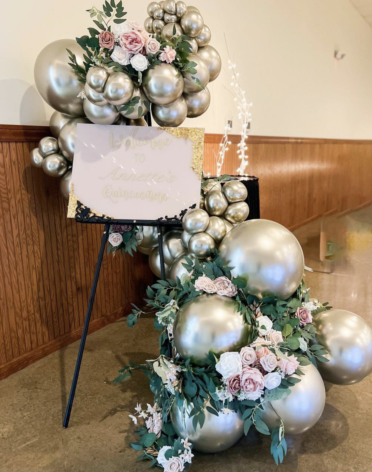 balloon ring centerpiece with greenery and signage for corporate events.