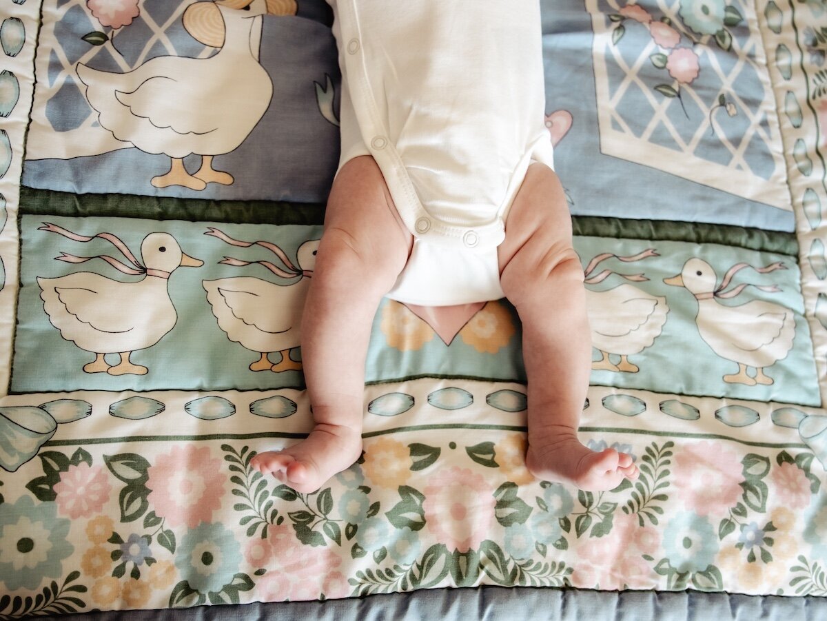 A newborn baby girl wearing a white onesie