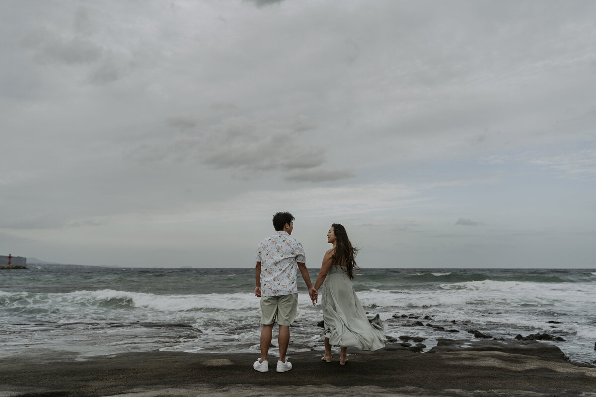 couple holding hands and staring at each other in Gwangchigi Beach jeju island