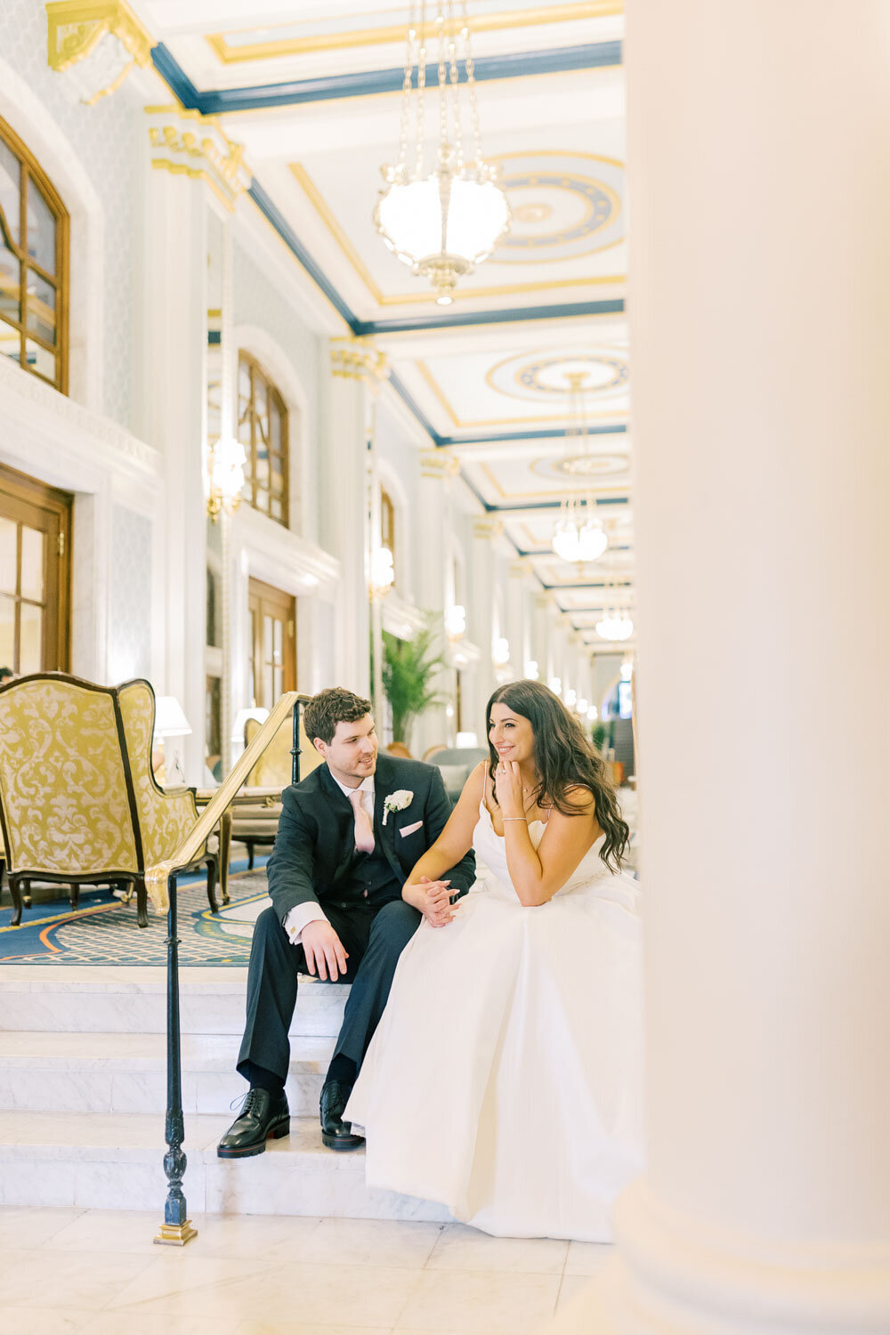 Bride and groom sitting together in elegant hotel lobby