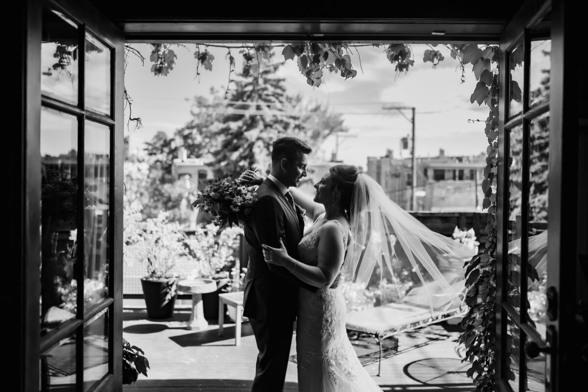 Bride and groom embrace  on a patio in chicago.