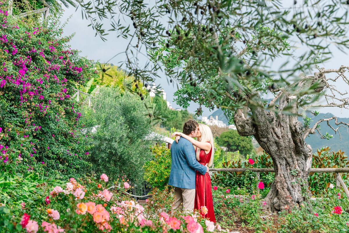 couple kisses in the garden at palazzo avino in ravello italy