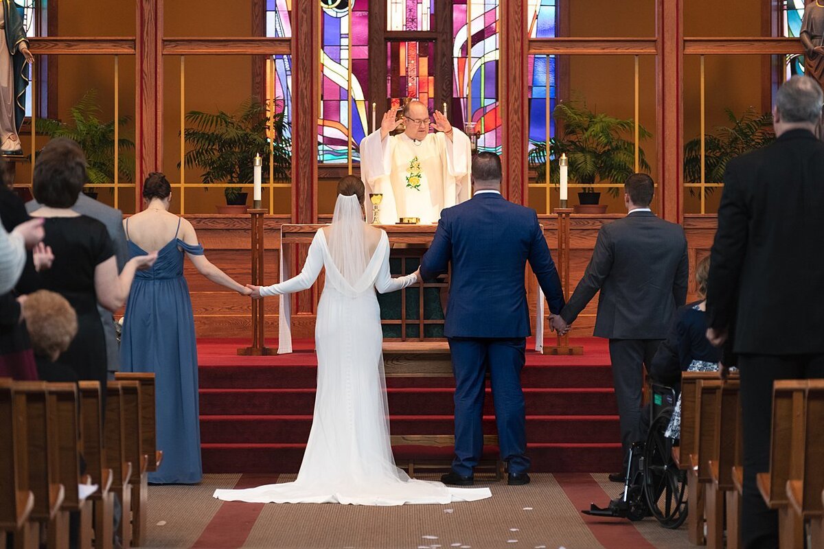NFL free agent Groom, Bride and Bridal Party joining hands to sing during wedding ceremony at St. Bonaventure Church in Pittsburgh, PA