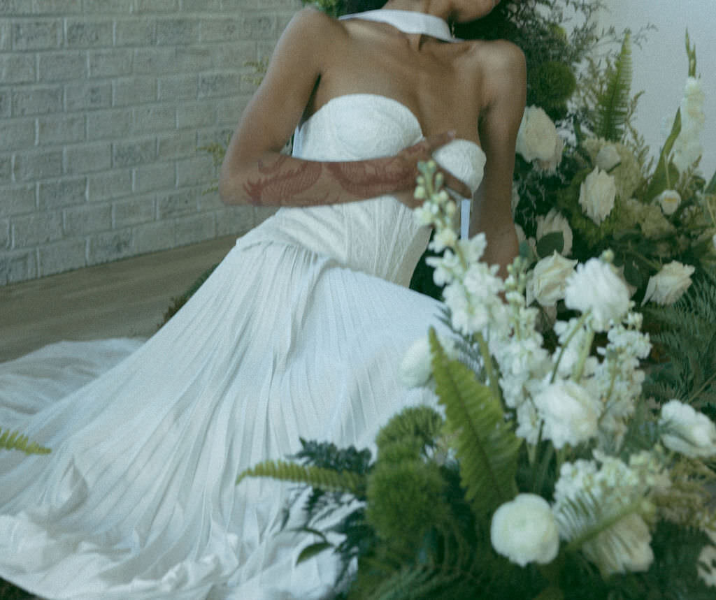 A person in a wedding dress laid out on the floor.