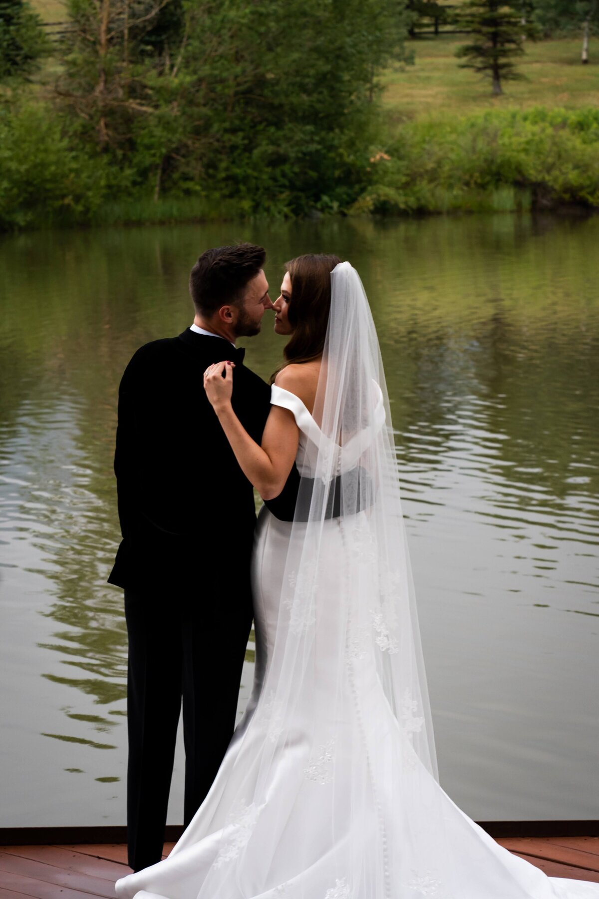 Bride and groom in front of the pond at Spruce Mountain Ranch in Colorado.