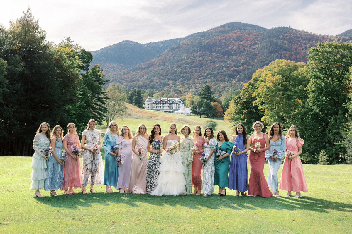 adirondack-mountain-wedding-16-bride-holding-bouquet-while-standing-with-bridesmaids-on-wide-mountain-lawn-at-adirondack-mountain-wedding-jenny-fu-studio