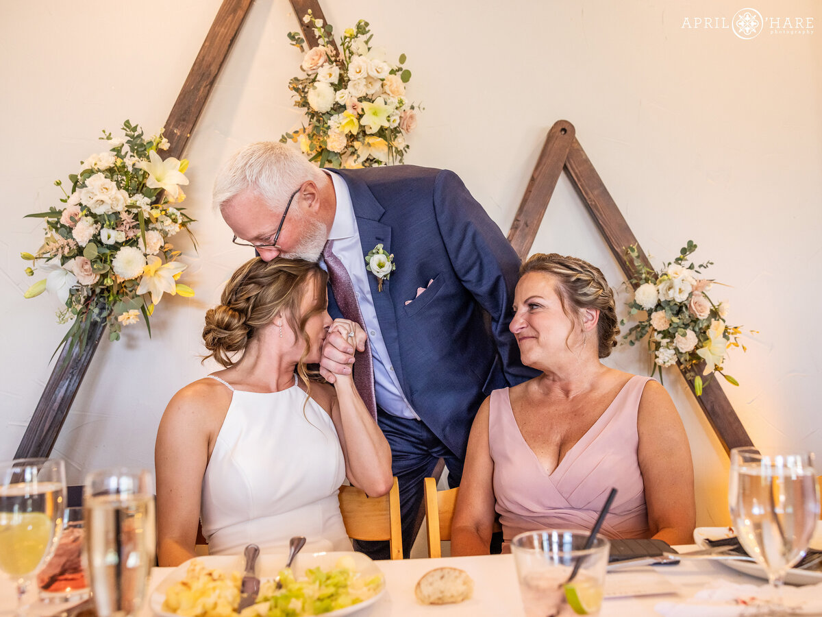 A father kisses her daughter on her wedding day in Breckenridge Colorado