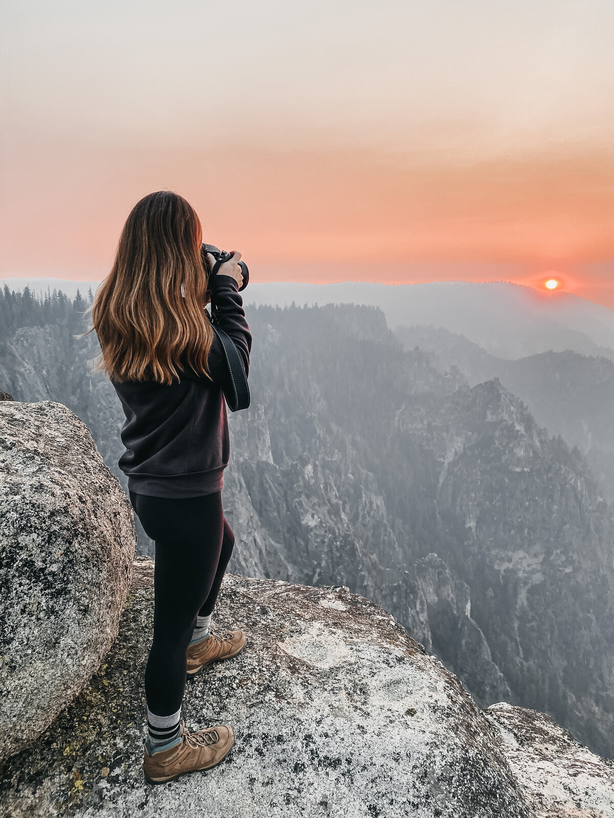 woman taking a picture at sunset