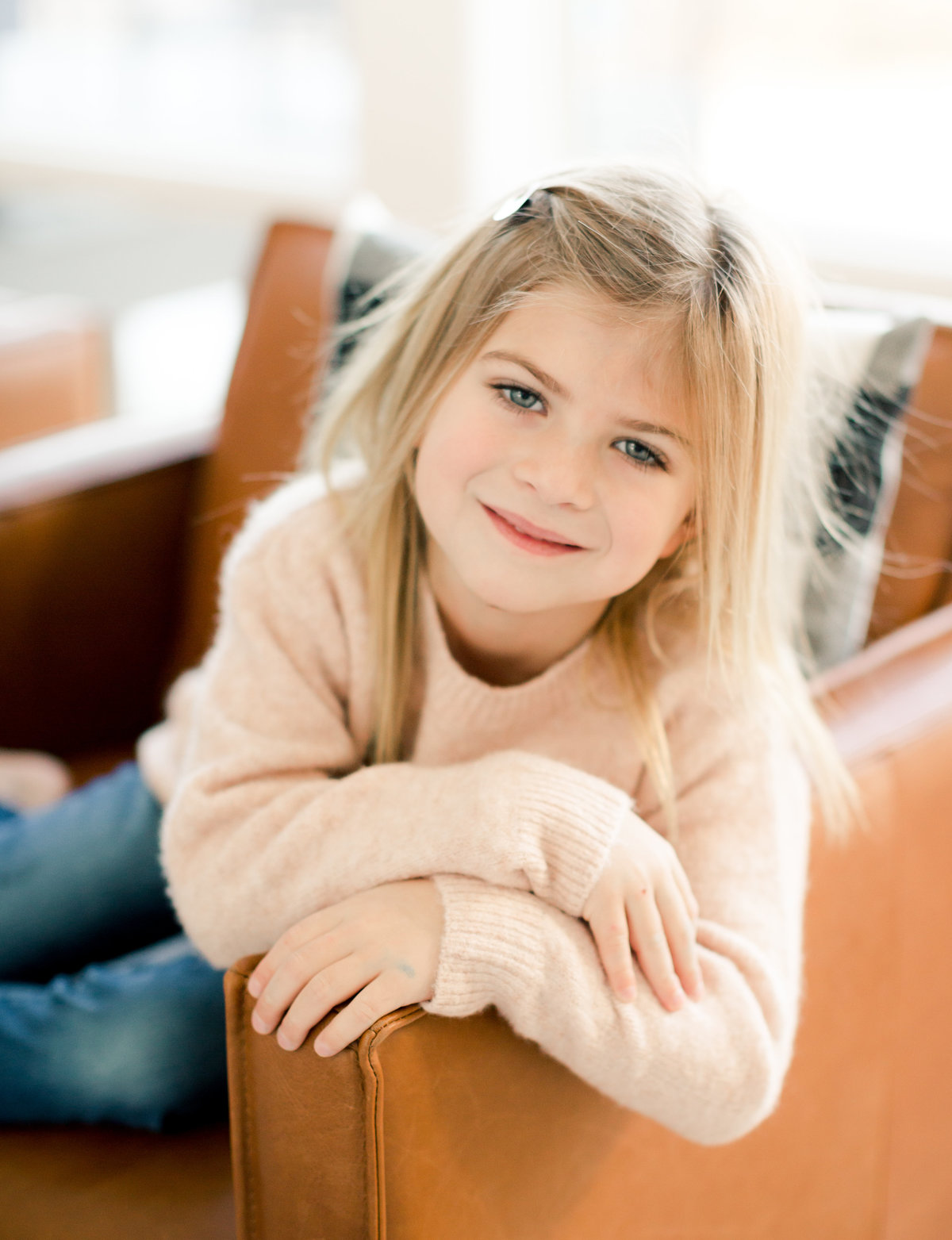sweet five year old sits in chair in new living room