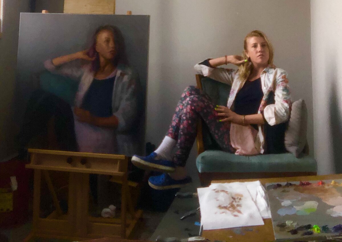 Artist Cam rose posing beside self portrait