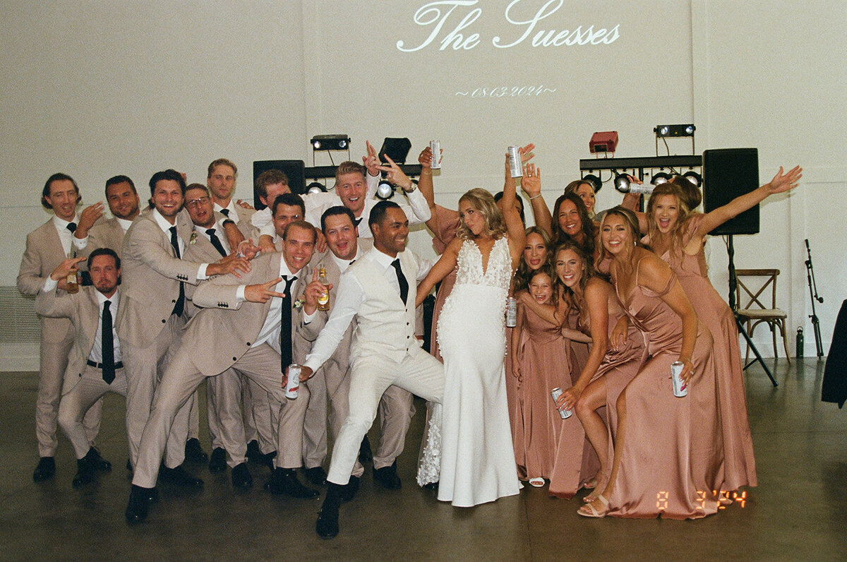wedding party posing on the dance floor together on film