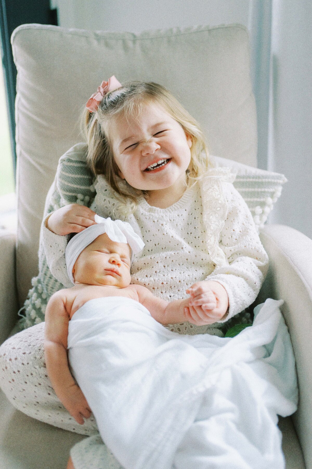 big sister holding newborn baby sister