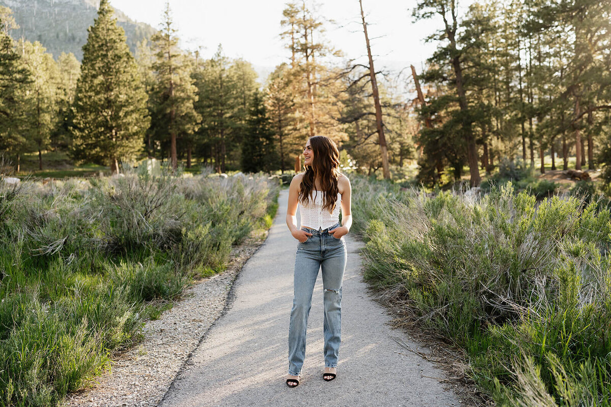 The-girl-bending down in forested area-senior-session-Rachel-Murray