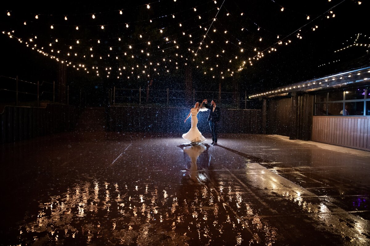 Bride twirls in the rain with her groom at Spruce Mountain Ranch.