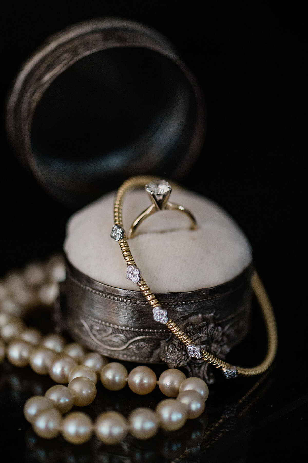 photo of a solitaire engagement ring in a ring box with a bracelet around it, taken by Jekyll Island Photographer, Rhonda Rowell