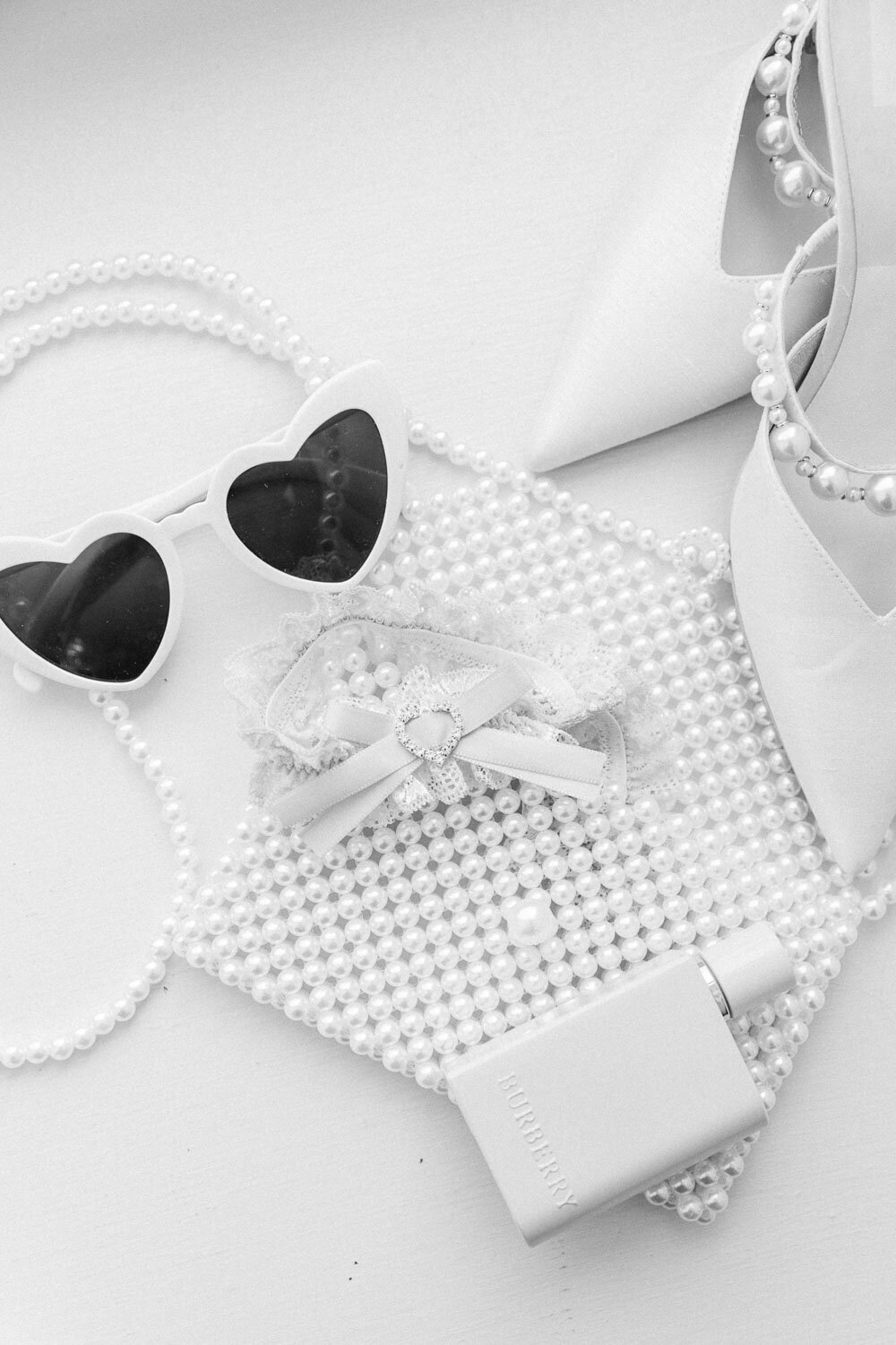 Black and white bridal details with pearls, shoes, and sunglasses