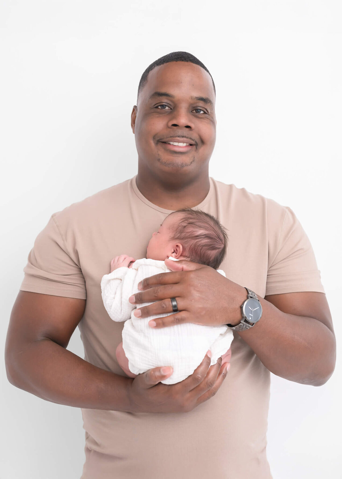 dad with new baby in neutrals on white backdrop