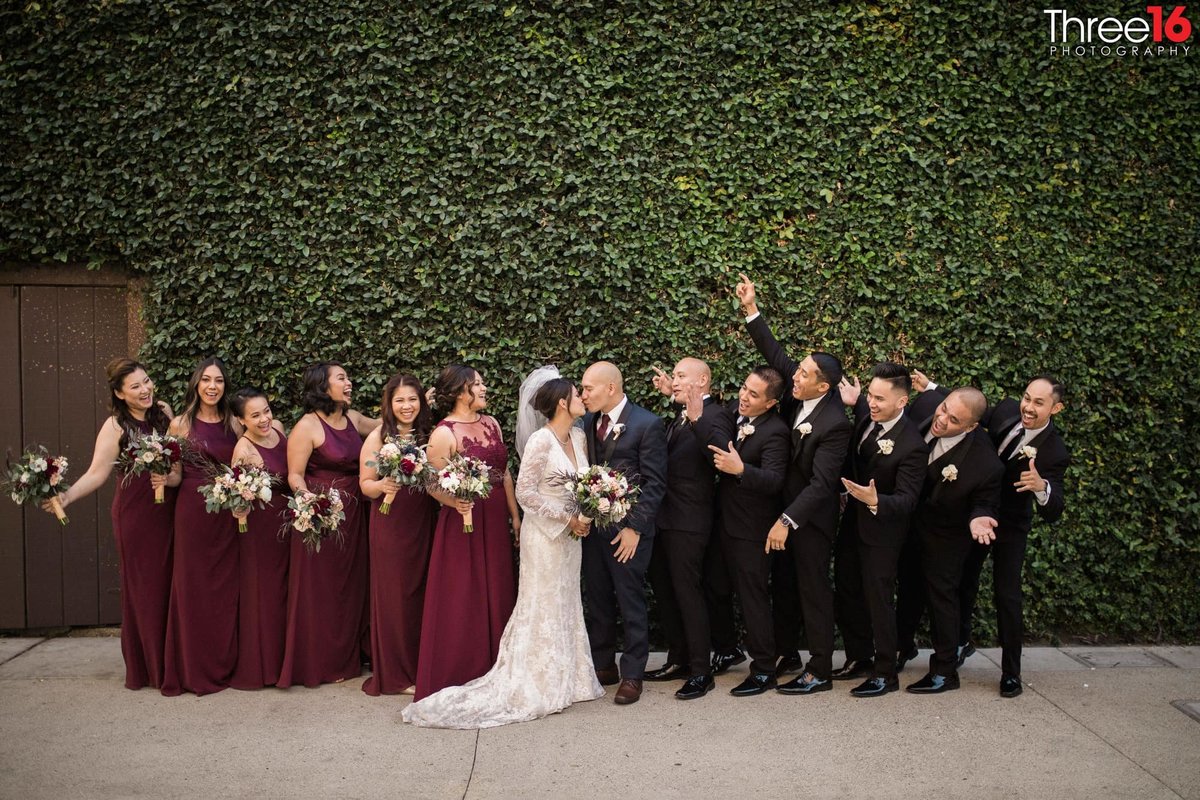 Bride and Groom share a kiss as the bridal party cheer