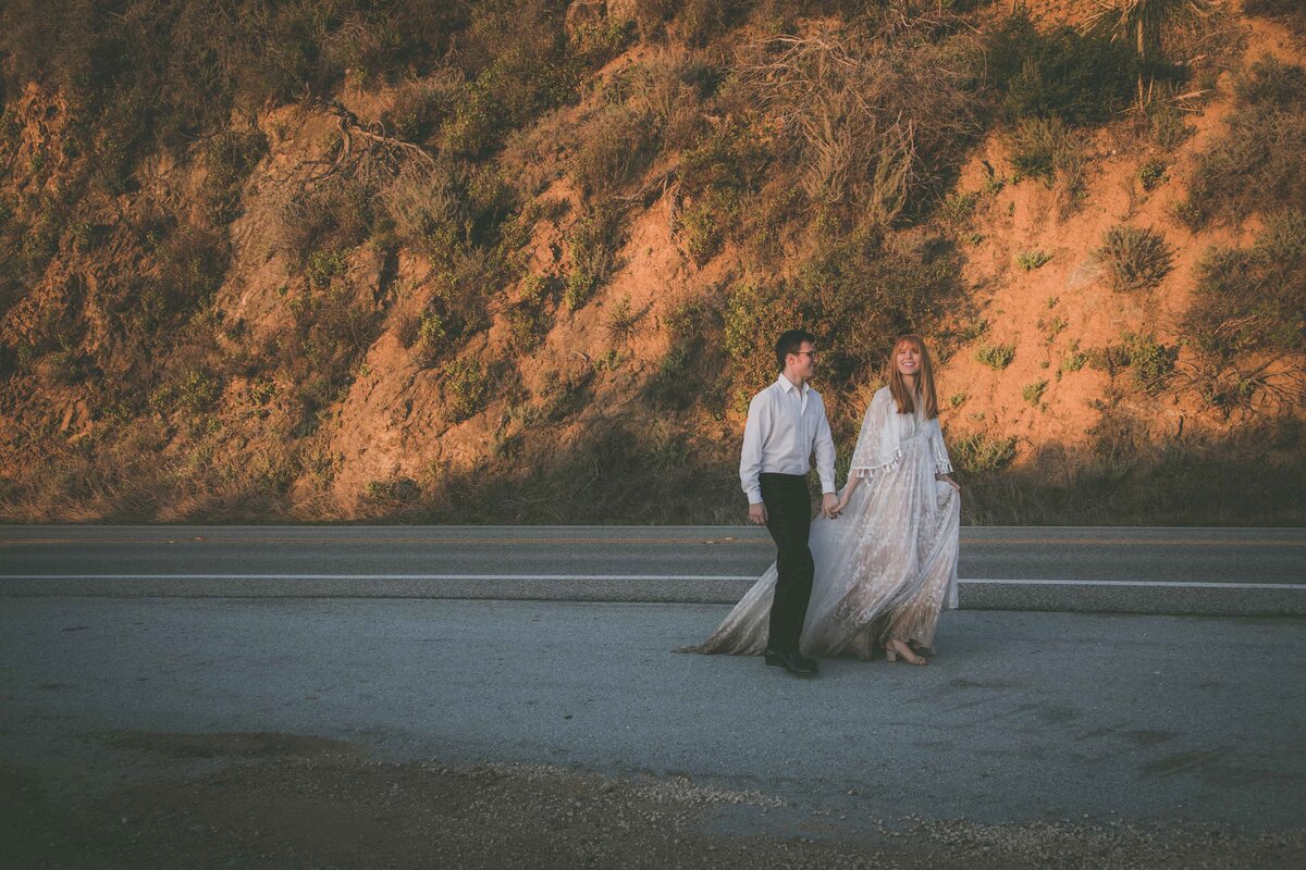 Couple walks down Highway 1 during their Big Sur elopement.