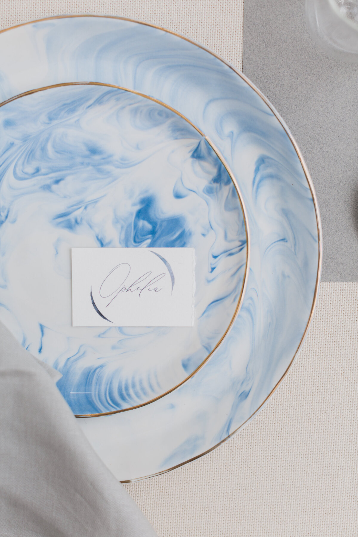 Luxury table setting with blue and white marble and gold rim fine tableware at Azure Romance wedding reception.
