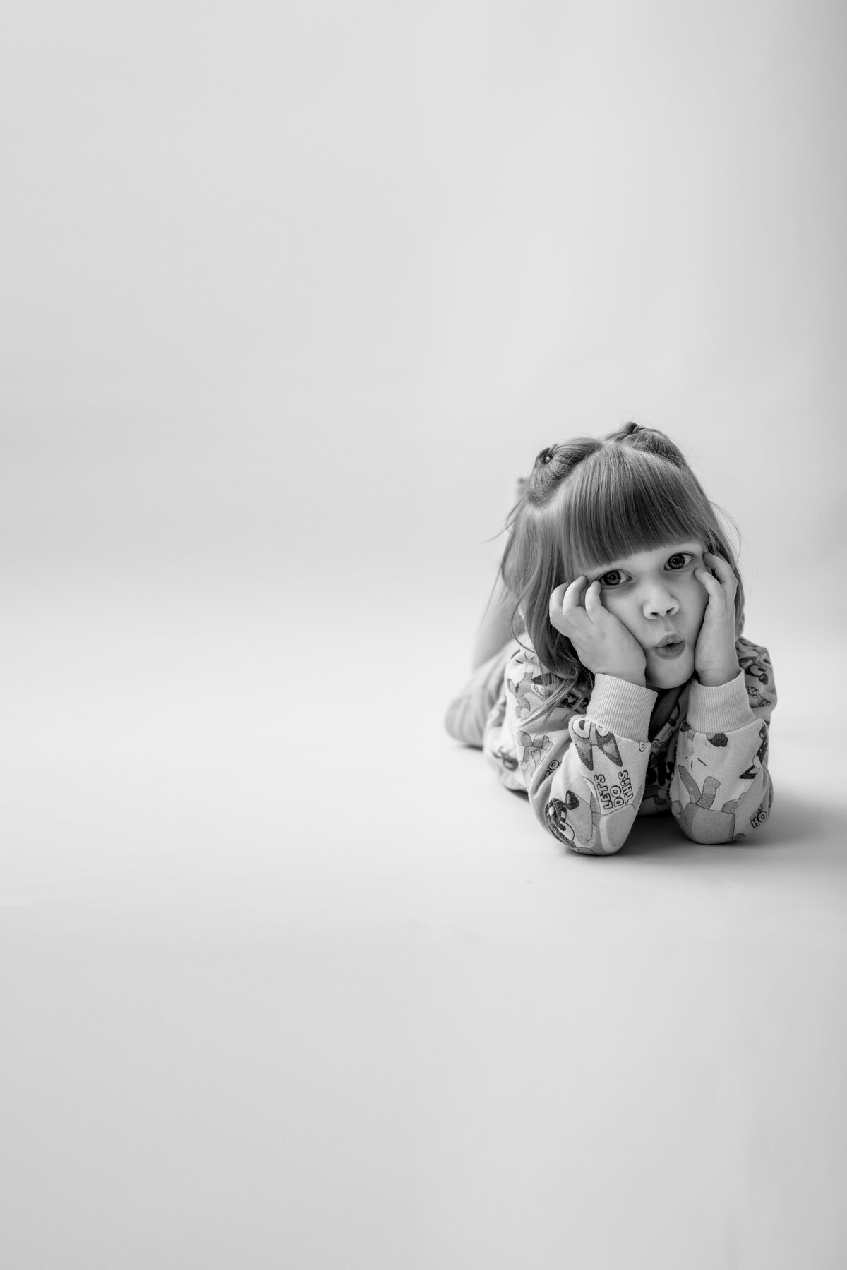 Toddler girl making kissy face for personality pictures in studio in Annapolis Maryland.