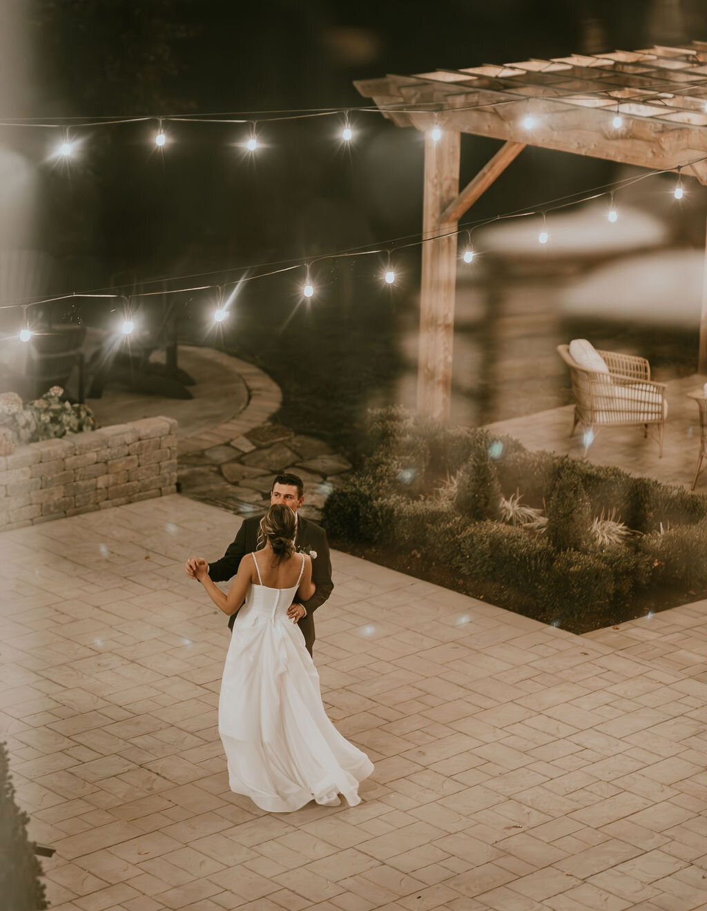 a bride  and groom having a private last dance on the stone patio in the gardens at Willowbrook wedding venue