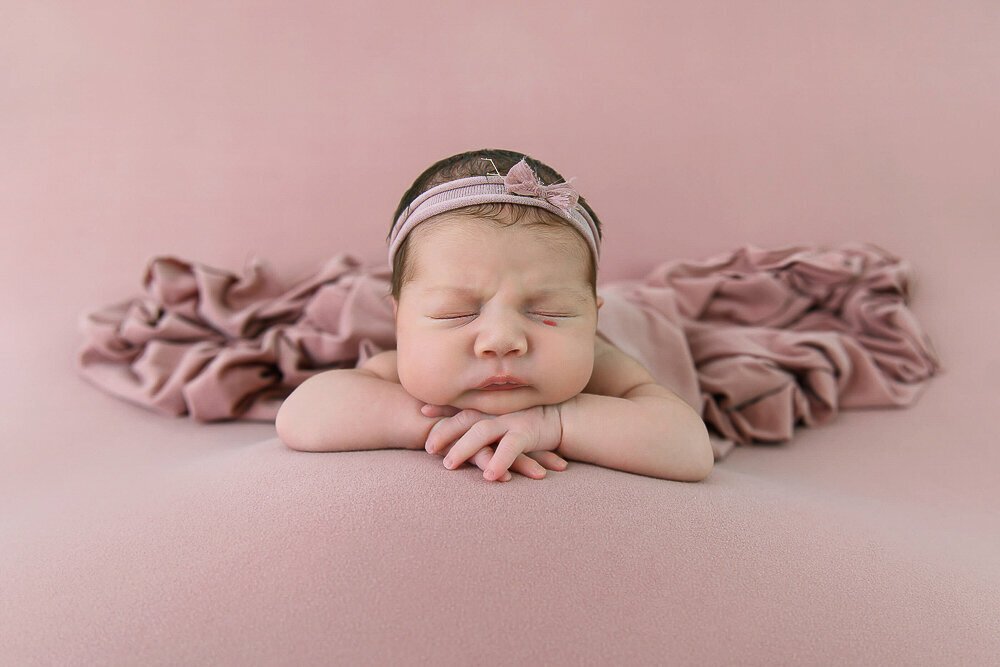 newborn girl on a pink background 