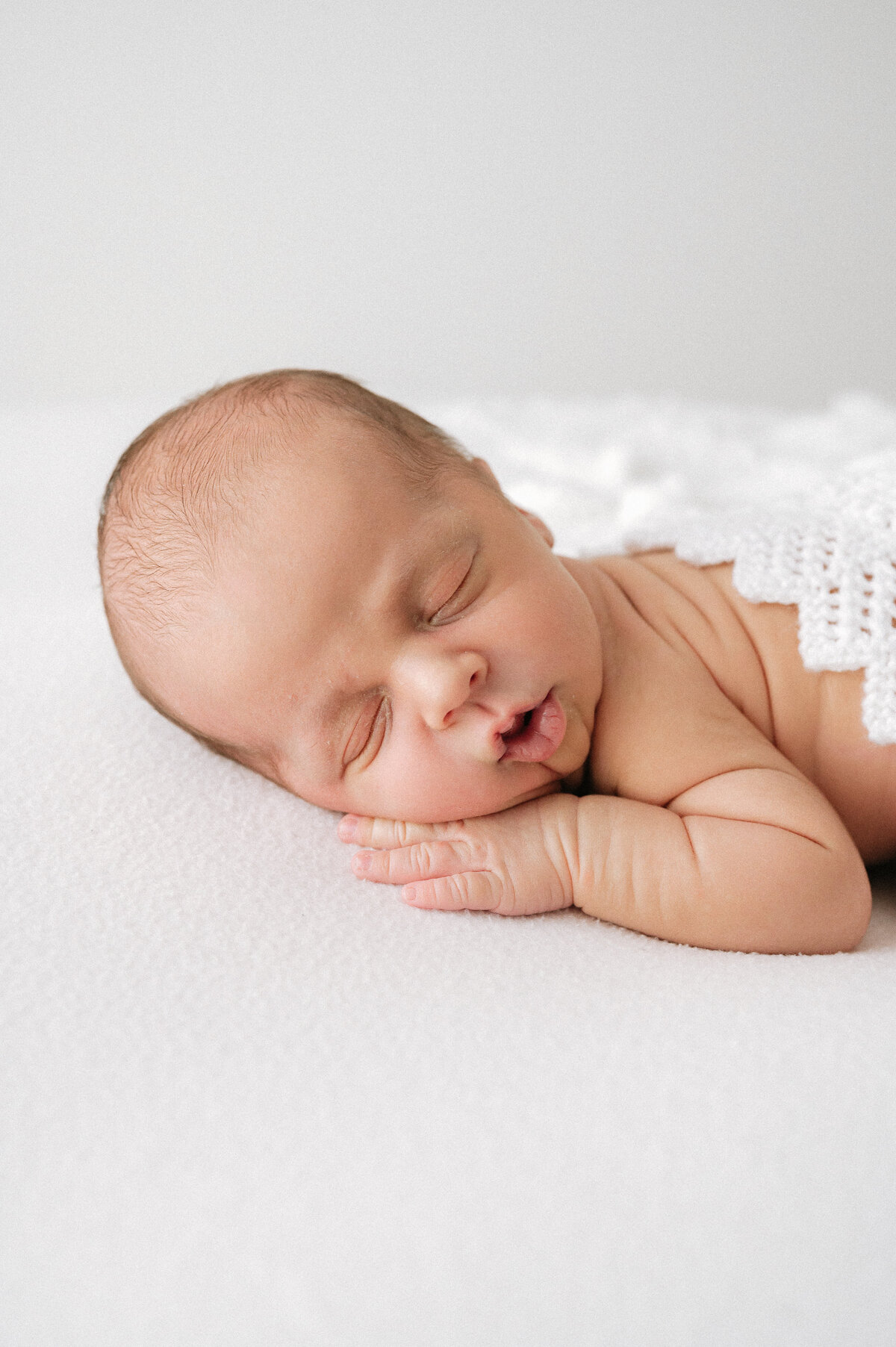 Cute newborn baby asleep on a white pillow